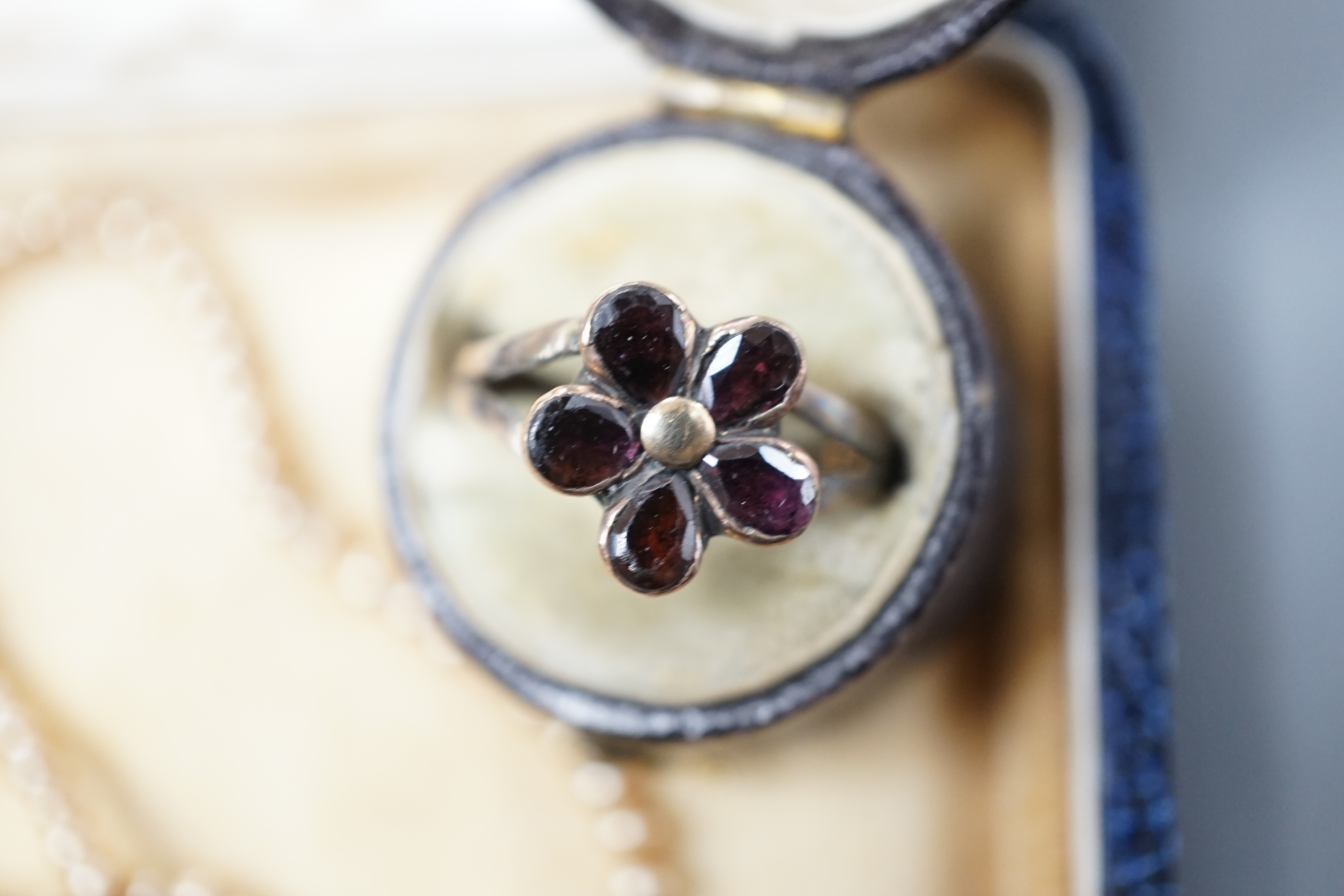 A simulated seed pearl necklace, oval brooch set with carnelian and a garnet set dress ring.